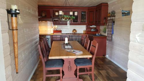 a small kitchen with a wooden table and chairs at Prima Lofoten in Myrland