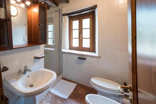 uma casa de banho com um lavatório, um WC e uma janela. em Agriturismo Monte Acuto em Umbertide