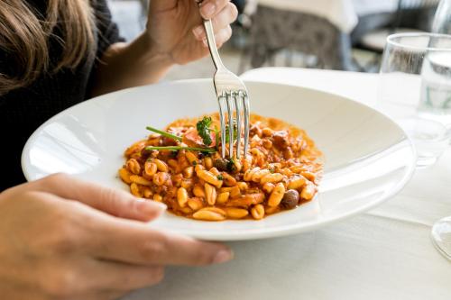 a person eating a plate of food with a fork at Belvedere in Stresa