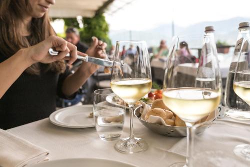 a woman sitting at a table with glasses of wine at Belvedere in Stresa