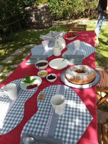 a picnic table with food on a red and white table cloth at Agriturismo campagna in compagnia in Vallo di Nera