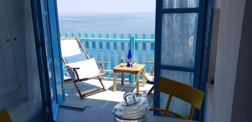 una puerta abierta a un balcón con mesa y sillas en Aegean Eye Apartments, en Kástron
