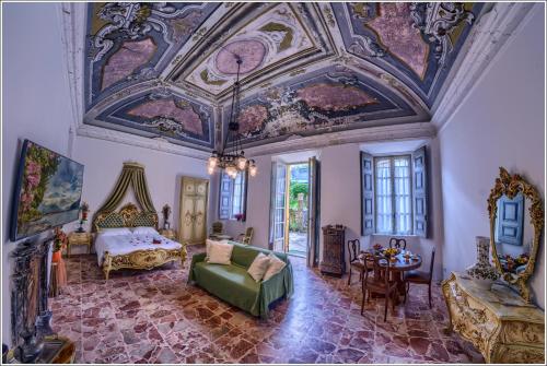 a room with a bed and a ceiling with paintings at Villa Vinicia in Domaso