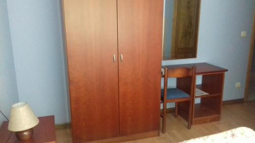 a bedroom with a wooden cabinet and a desk at Hotel Brisas del Sella in Ribadesella