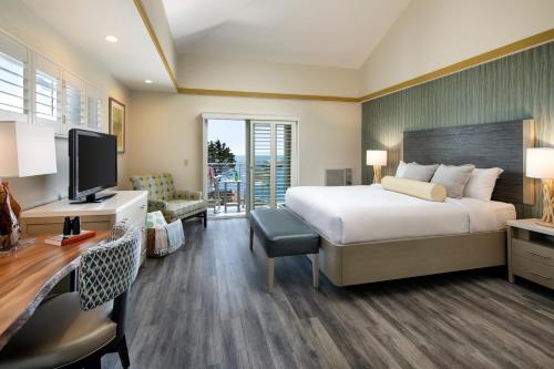 a hotel room with a bed and a desk and a television at Inn at the Cove in Pismo Beach
