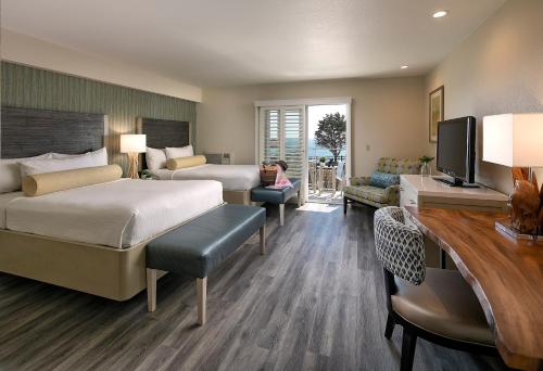 a hotel room with two beds and a tv at Inn at the Cove in Pismo Beach