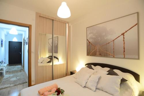 ein Schlafzimmer mit einem Bett mit einem großen Gemälde an der Wand in der Unterkunft Apartment Lux Lomina in Čačak