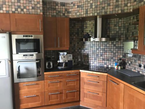 a kitchen with wooden cabinets and stainless steel appliances at BoSmart Apartments in Gothenburg