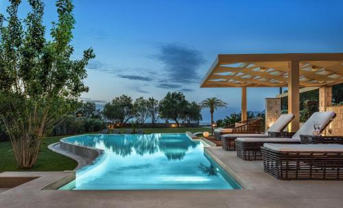 een zwembad met ligstoelen en een parasol bij Villa Elvina in Kissamos