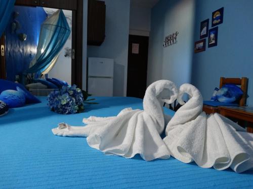 two swans made out of towels on a bed at Athina-Milina in Milína