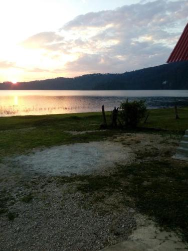 a sunset over a body of water with a tree at Cabañas Islas de Tziscao in Santiago