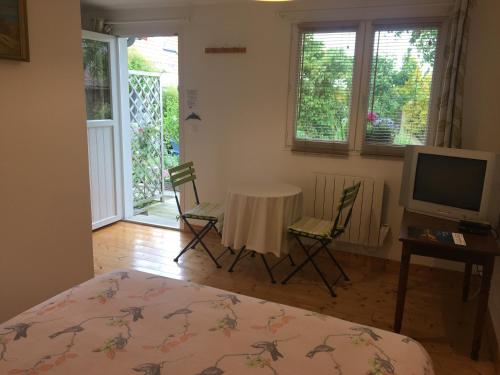 - une chambre avec une table, des chaises et une télévision dans l'établissement Wissant l'Opale, à Wissant