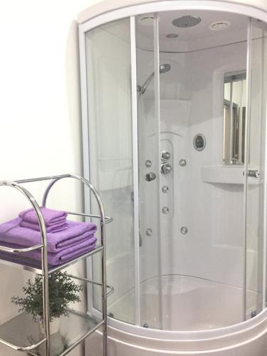 un bagno con doccia e asciugamani viola su una mensola di Studio Lavander a Kaštela (Castelli)