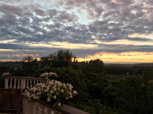 a view of a sunset from a balcony with flowers at Rossella alla Villarella dei Tulipani in Asti