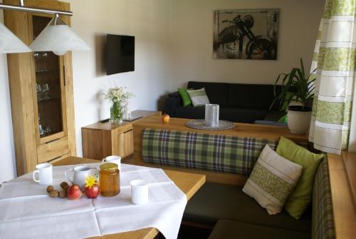 a living room with a table and a couch at Moosgut in Abtenau