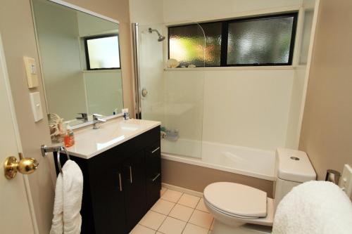a bathroom with a sink and a toilet and a mirror at Pacific View Bed and Breakfast in Wellington