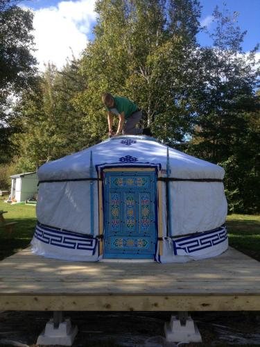 a man standing on top of a blue and white trailer at Cabot Shores in Indian Brook