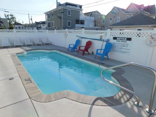 a swimming pool with chairs and a table at Blue Water Inn in Ocean City