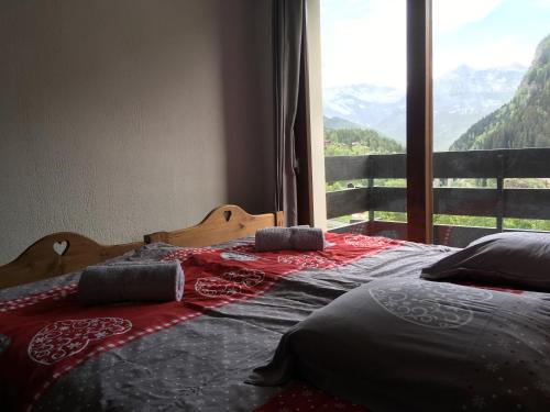 two beds in a room with a large window at Les Esserts in Les Houches