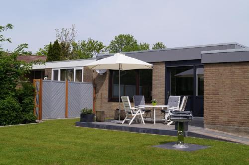 a patio with an umbrella and a table and chairs at plattedijk 25-47 in Lemmer