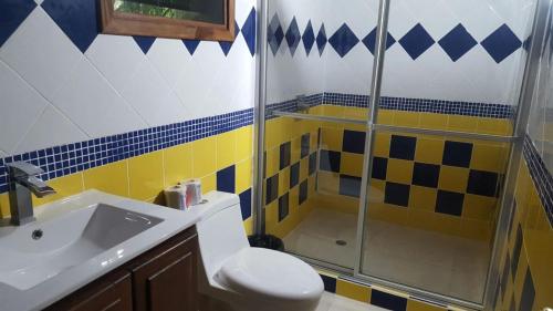a bathroom with a shower and a toilet and a sink at Hotel Salvador Gaviota in Lívingston