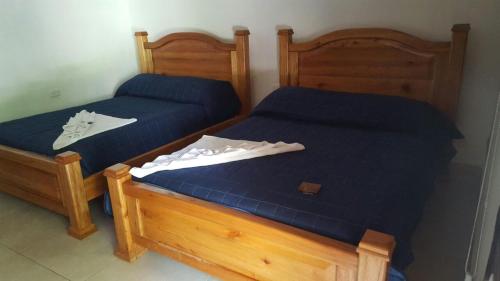 two twin beds in a room with blue sheets at Hotel Salvador Gaviota in Lívingston