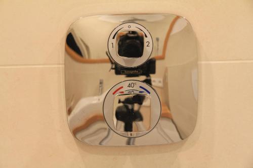 a mirror on a wall with a reflection of a camera at Comfort Lodging Stueckenfeld in Hannover