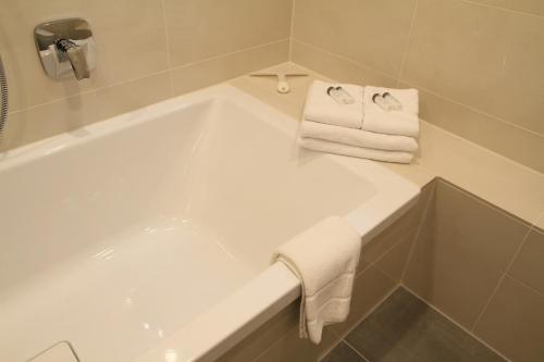 a bathroom with a bath tub with two towels at Comfort Lodging Stueckenfeld in Hannover