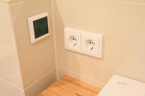 a bathroom with two light switches on the wall at Comfort Lodging Stueckenfeld in Hannover