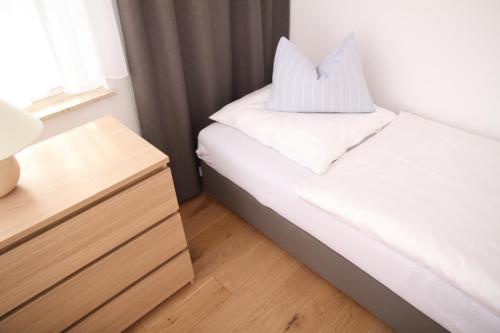 a small bedroom with a bed and a night stand at Comfort Lodging Stueckenfeld in Hannover