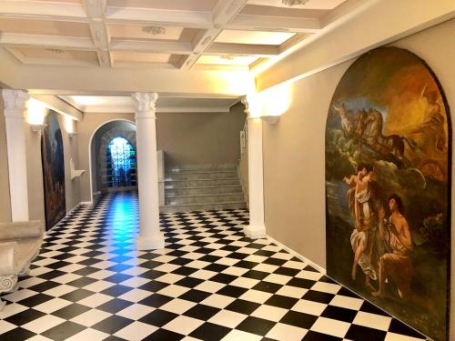a room with a checkered floor and a painting on the wall at Nettuno Suite in Siracusa