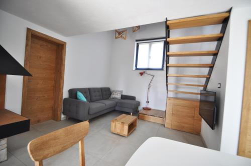 ein Wohnzimmer mit einem Sofa und einer Treppe in der Unterkunft Casa Fogoler Fažana in Peroj