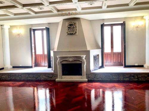 a living room with a fireplace and a red floor at Nettuno Suite in Siracusa
