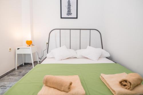 een slaapkamer met een bed met groene lakens en witte kussens bij Apartments History in Split