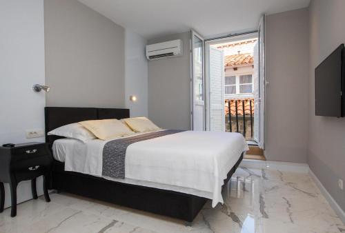 ein Schlafzimmer mit einem großen Bett und einem Fenster in der Unterkunft Soleil Luxury Rooms Old town in Dubrovnik