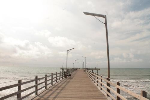 a wooden pier with street lights and the ocean at Hotel Mar del Viento in San Bernardo del Viento