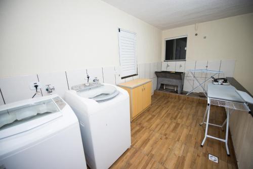 a kitchen with a sink and a washing machine at Vila Dumont no Centro de Foz in Foz do Iguaçu