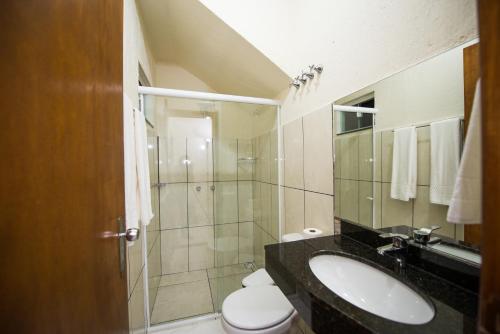 a bathroom with a sink and a toilet and a shower at Vila Dumont no Centro de Foz in Foz do Iguaçu