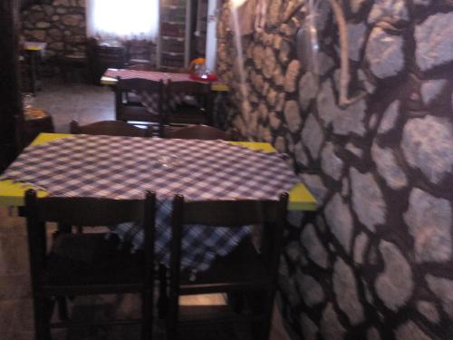 a table and chairs with a checkered table cloth on a wall at Guest House Vila Banjica in Pirot
