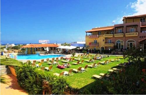 een resort met een zwembad en stoelen en een gebouw bij Creta Mar-Gio in Malia