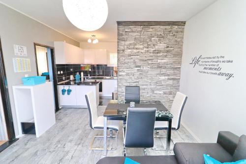 a dining room with a table and chairs and a kitchen at Apartment Marjana Prižba in Prizba