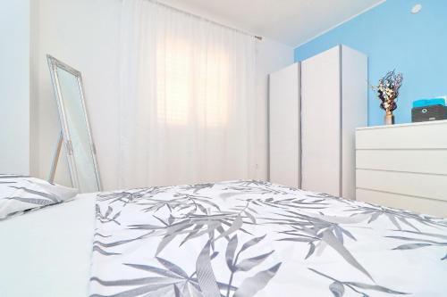a bedroom with a bed with a plant printed bedspread at Apartment Marjana Prižba in Prizba