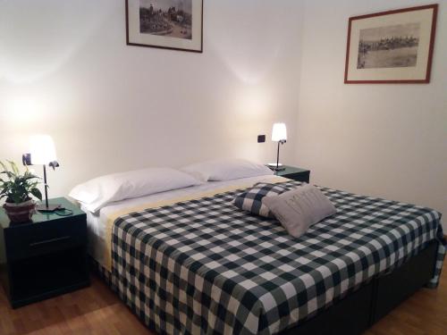 um quarto com uma cama com um cobertor xadrez em B&B il Cortile Malpensa em Casorate Sempione