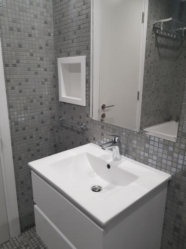 a bathroom with a white sink and a mirror at Yialos Holiday Apartments in Pervolia