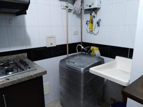 a small kitchen with a sink and a trash can at Apartamento 28U in Bucaramanga