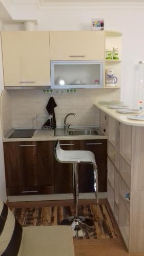 a small kitchen with a sink and a stool at Studio Morski Briz in Burgas City