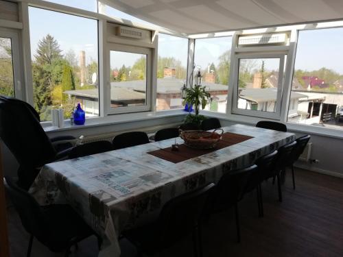 a dining room with a table and chairs and windows at Ferienwohnung am Torbogen Nr.3 in Lübbenau