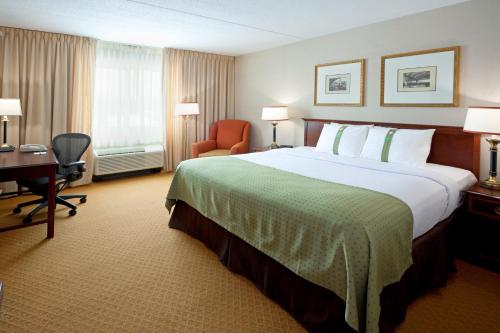 Habitación de hotel con cama grande y escritorio. en Holiday Inn Budd Lake - Rockaway Area, an IHG Hotel, en Budd Lake