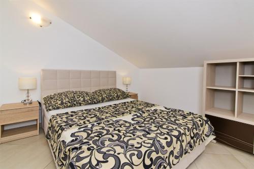 a bedroom with a bed with a black and white comforter at Villa Sophie in Betina