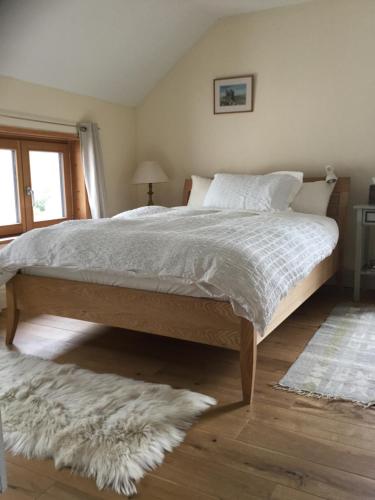 a bedroom with a large bed with a white comforter at Kenmare Eco Lodge in Kenmare